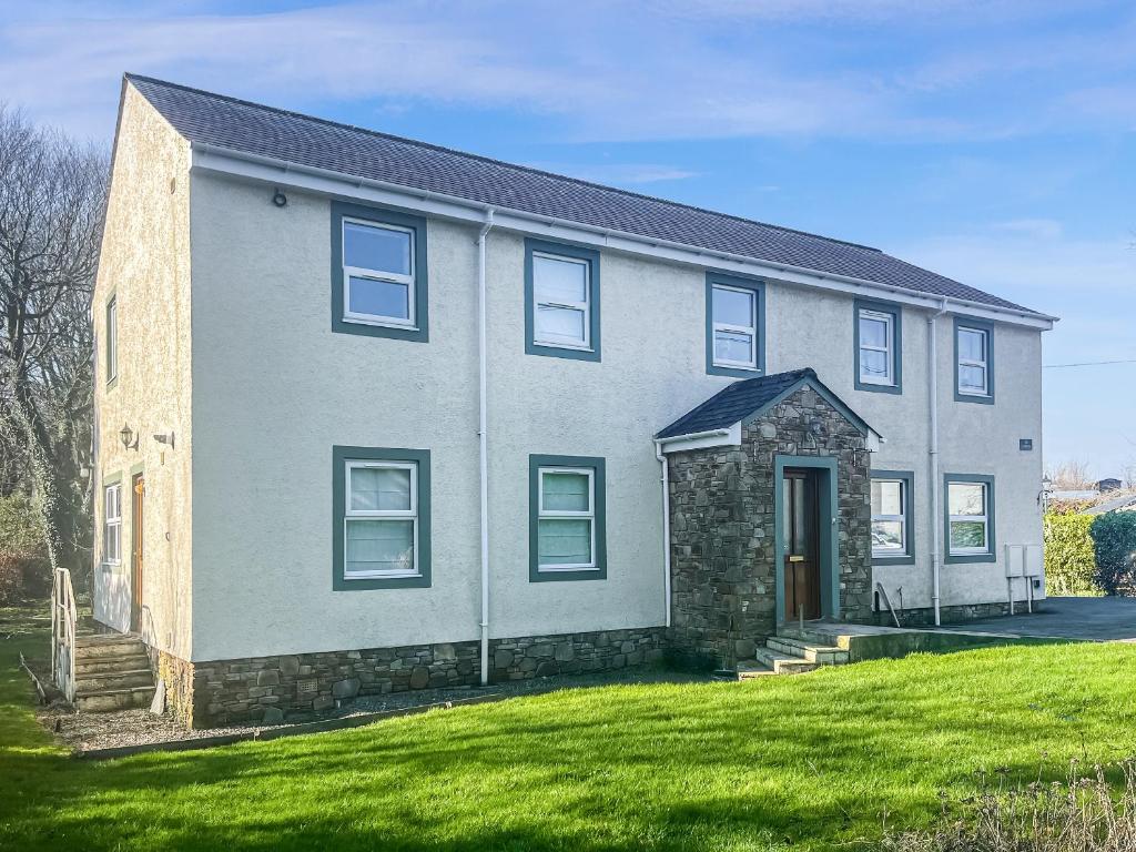 a large brick house with a grass yard at Gokula House in Cockermouth