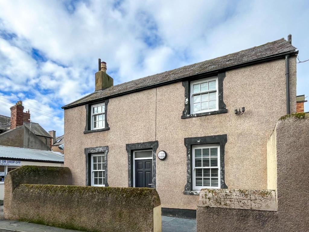 a brick house with a black door and windows at Albert Cottage in Llandudno