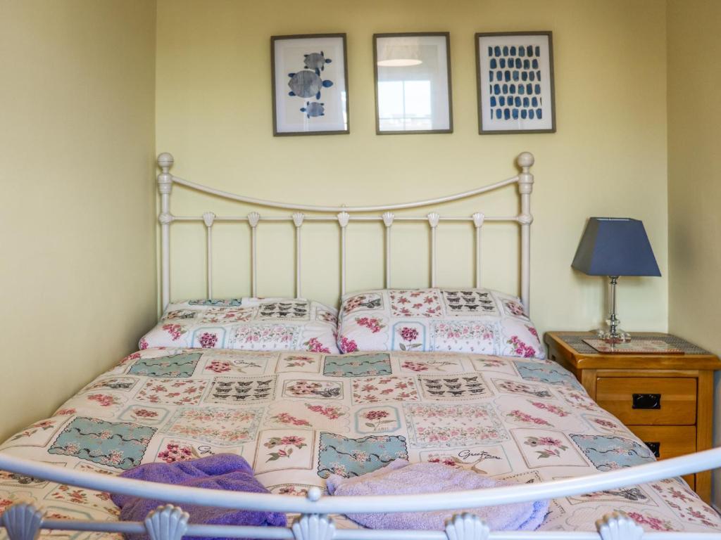 a bedroom with a bed with a metal frame at The Cottage in Broad Haven