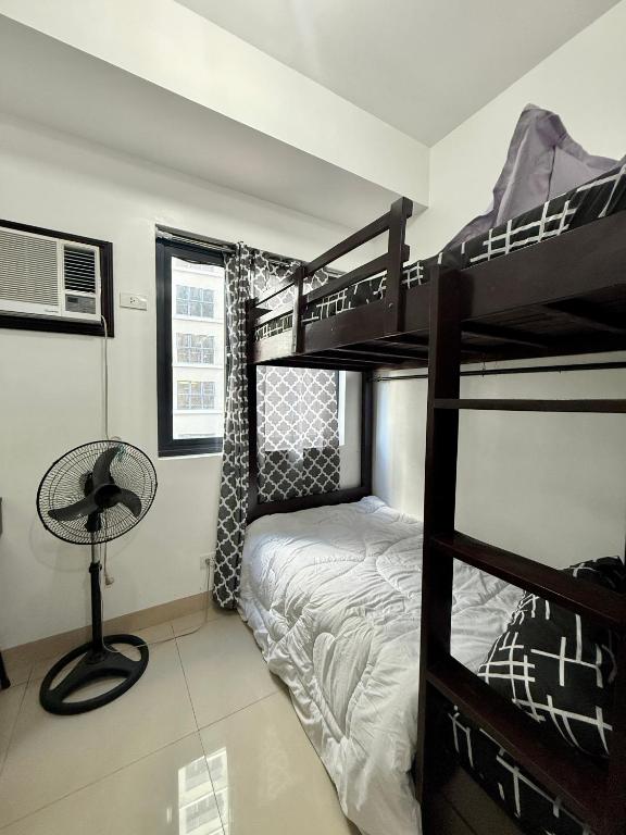 a bedroom with two bunk beds and a desk at Blanc Suite in Dasmariñas