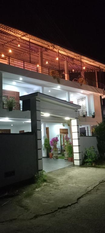 a lit up building with a garage at night at Rohan's Residence in Kandana