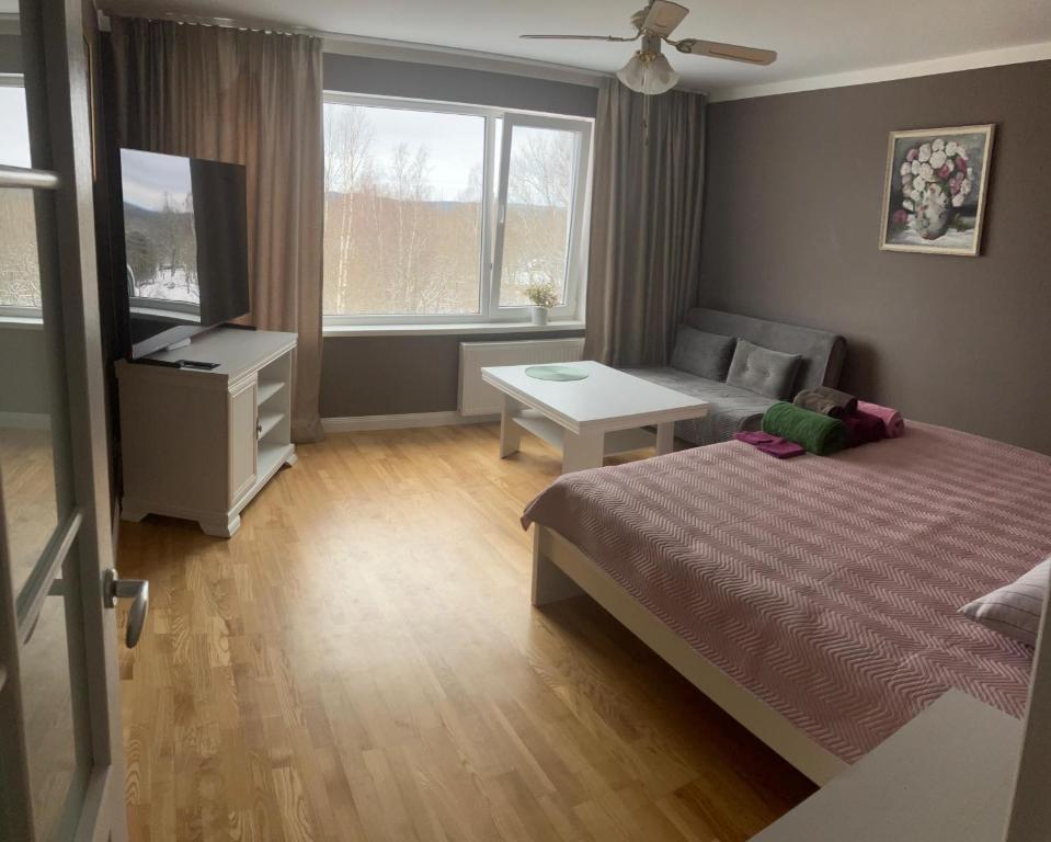 a bedroom with a bed and a tv and a table at Kovarnu street apartment in Cēsis
