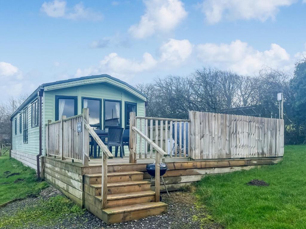 a blue tiny house with stairs and a fence at Oak Tree Lodge - Uk51429 in Westward