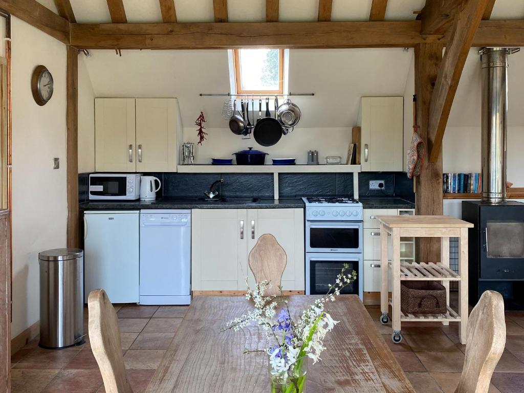 a kitchen with white appliances and a table with chairs at The Old Carthouse in Steyning