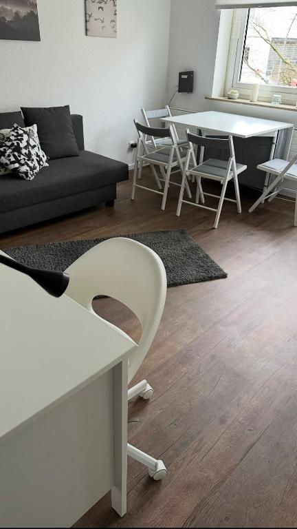 a living room with a couch and a table and chairs at FeWo am Deich 4 in Bremerhaven