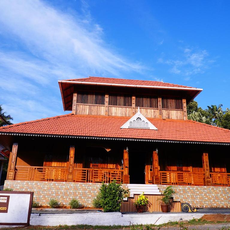 a large building with a red roof and a building at JackRoot Athirappilly in Kallana