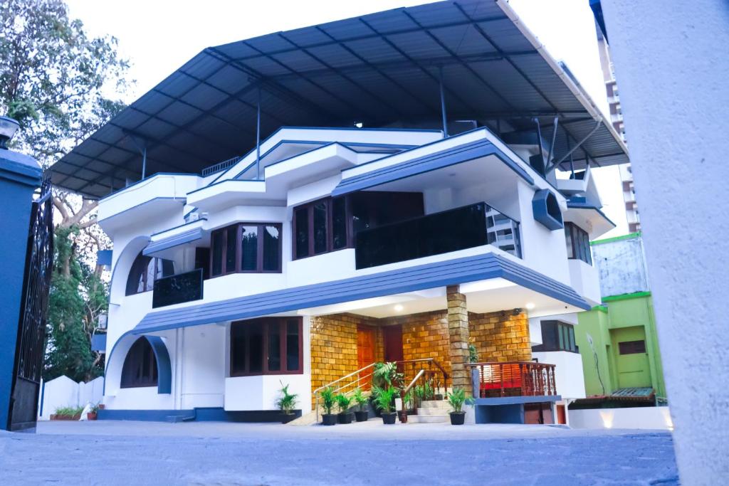 a white house with a blue awning at Luxury Villa in Falnir in Mangalore