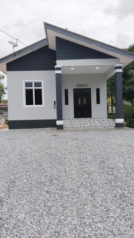 a house with a large driveway in front of it at Dhila Homestay Jalan Pasir Mas Rantau Panjang in Pasir Mas