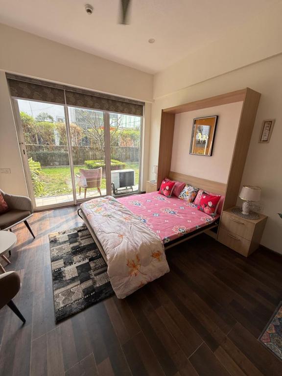 a bedroom with a large bed and a large window at AeroNest Luxe in Zirakpur
