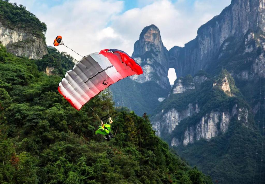 a person is in the air with a parachute at Zhangjiajie Homeinn Hotel- New Hotel,Free Breakfast, Free Self-Service Laundry & Drying, Attraction Tickets Serivce in advance,Toursim info in Zhangjiajie
