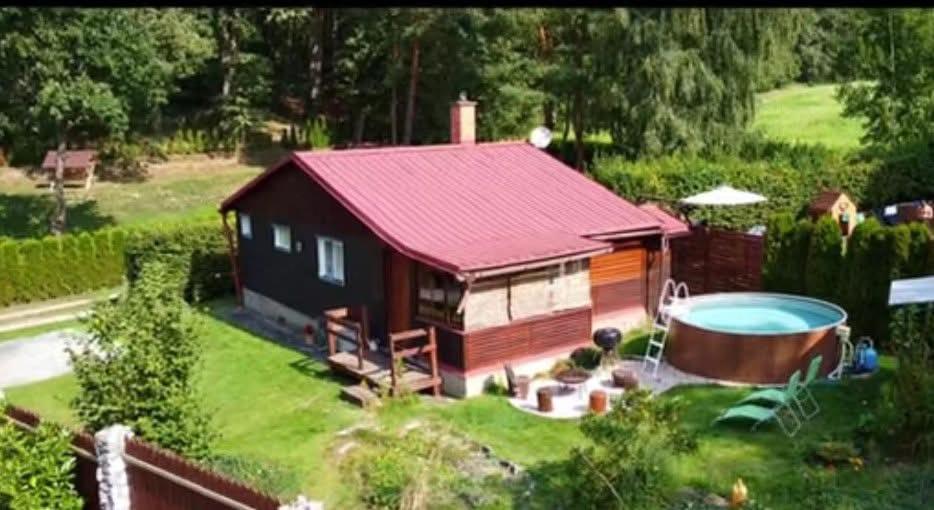 a small house with a hot tub in the yard at Chata Borecké skály in Ktová