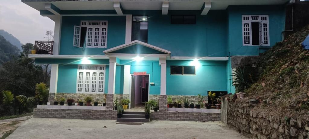 a blue house with a red door at Mamta's Homestay in Aritar