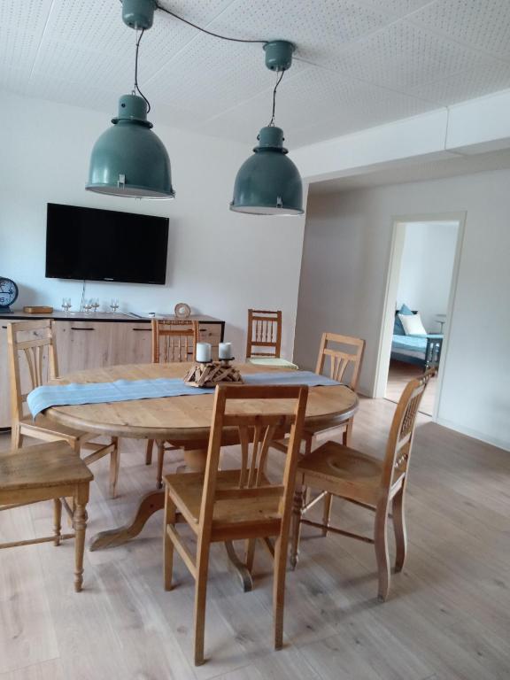 a dining room with a wooden table and chairs at Ferienwohnung Schimpf in Sosberg