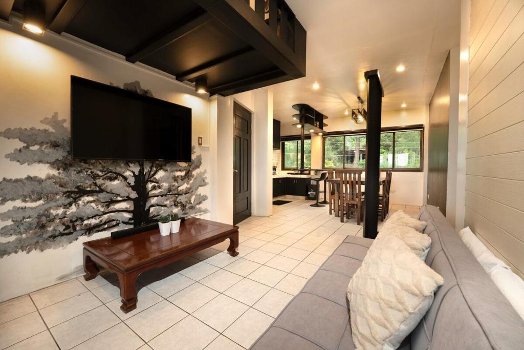a living room with a couch and a flat screen tv at 3BR The South Drive Loft 301 in Baguio