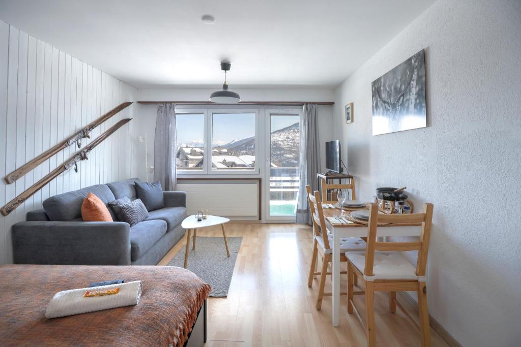 a living room with a couch and a table at Le Tracouet - Central et cosy studio in Nendaz