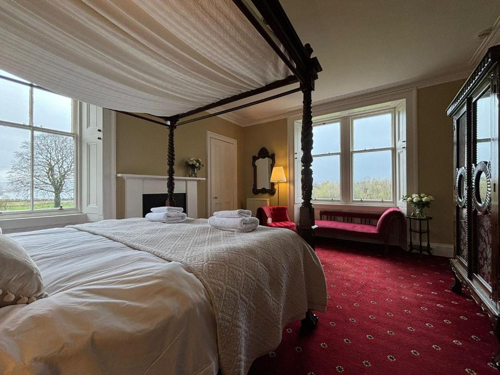 a bedroom with a canopy bed with a red carpet at Blarcreen in Oban