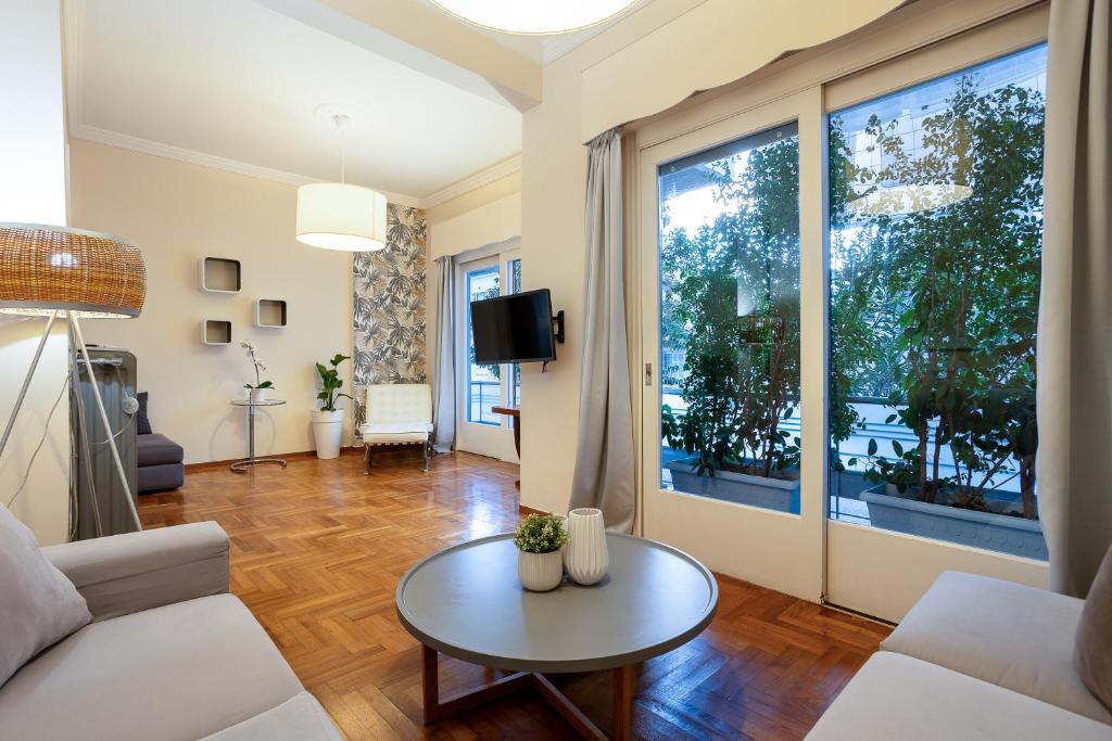 a living room with a couch and a table at Elegant Garden Apartment Walk to Kalamata Center 2BR in Kalamata