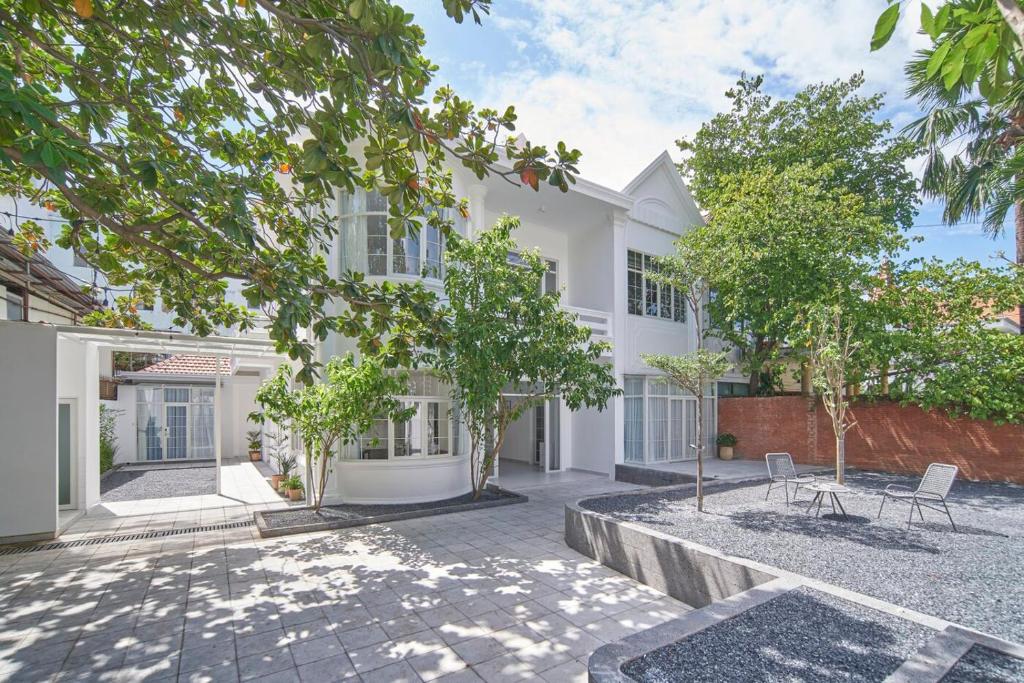 a white building with trees in front of it at Express by M Village 47 Thảo Điền, a brand of Modern Village Lifestyle in Ho Chi Minh City