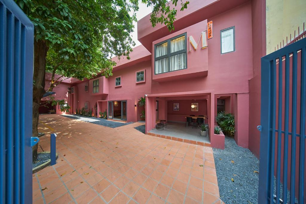 a pink building with a courtyard in front of it at Express by M Village Hồ Biểu Chánh, a brand of Modern Village Lifestyle in Ho Chi Minh City