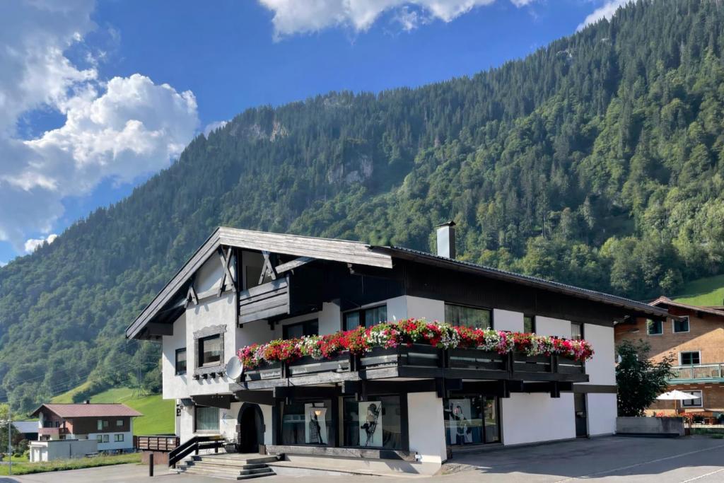a building with flower boxes on it in front of a mountain at K-Appartements Klösterle in Klösterle