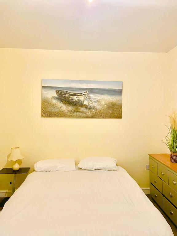 a bedroom with a bed and a painting on the wall at Babo Bolton room en suite in Farnworth
