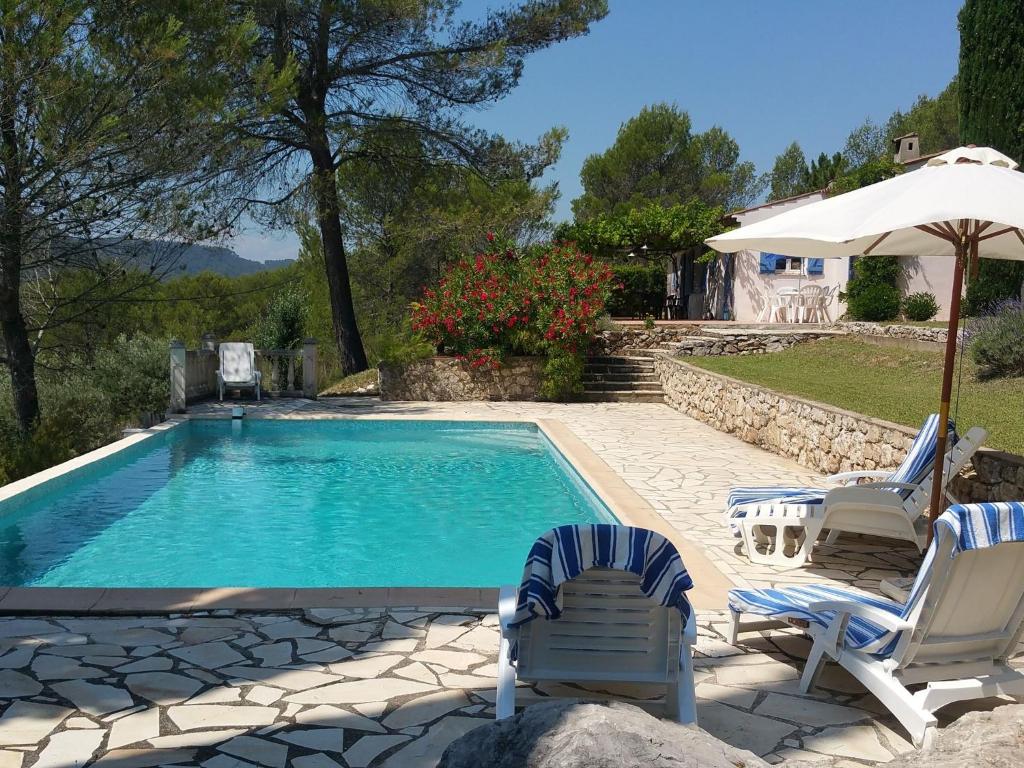 サレルヌにあるModern Villa With Swimming Pool in Salernes Franceのスイミングプール(椅子2脚、パラソル付)