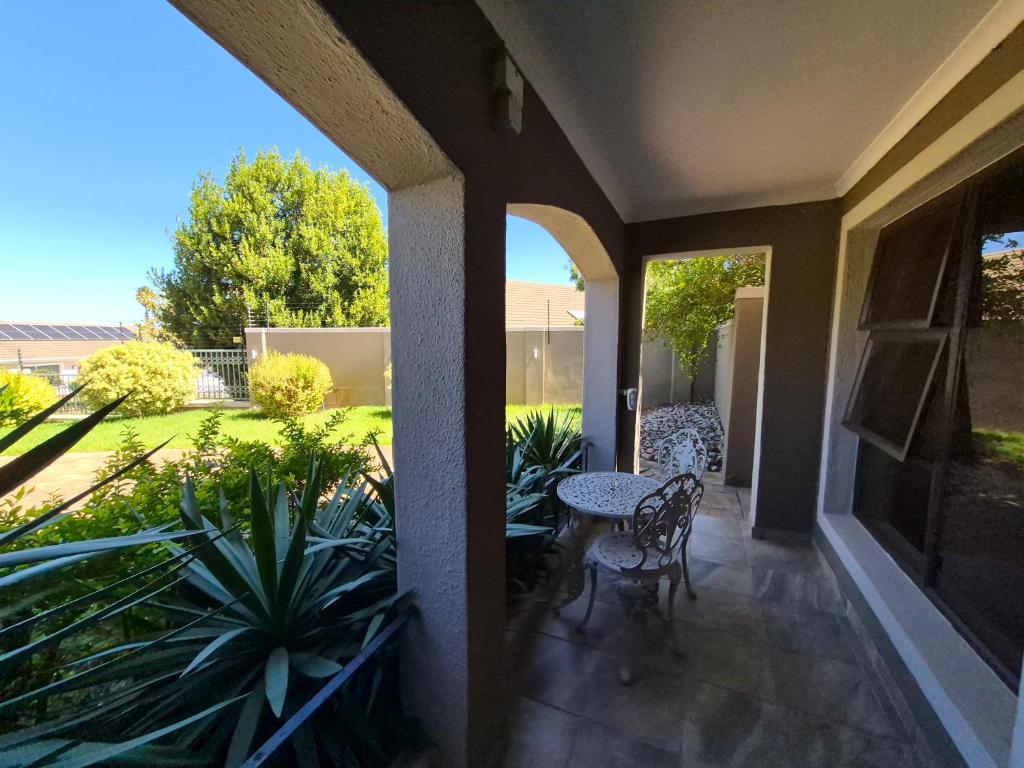 a patio with a table and chairs and plants at Somerset Garden Studio in Somerset West