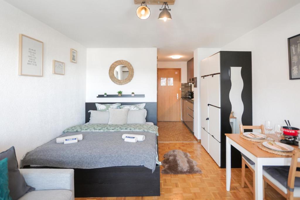 a small bedroom with a bed and a kitchen at Le Cleuson - centré avec vue in Nendaz