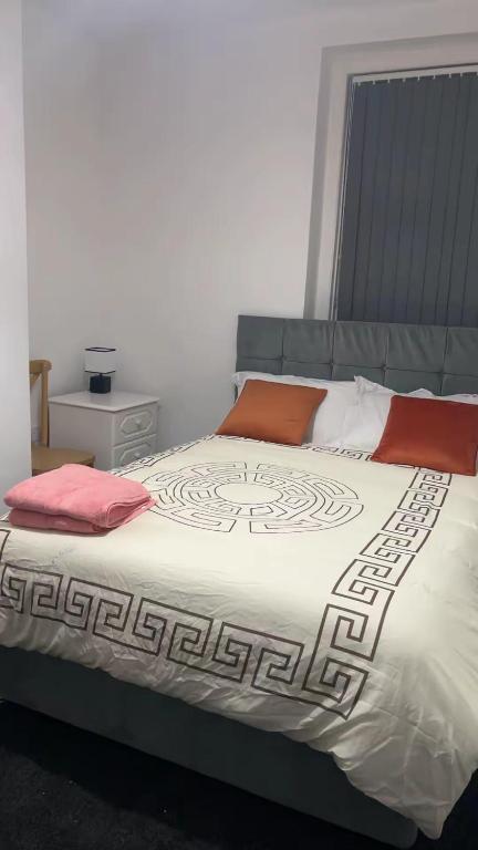 a bedroom with a large bed with red pillows at PLUS Properties Westport 1 in Stoke on Trent