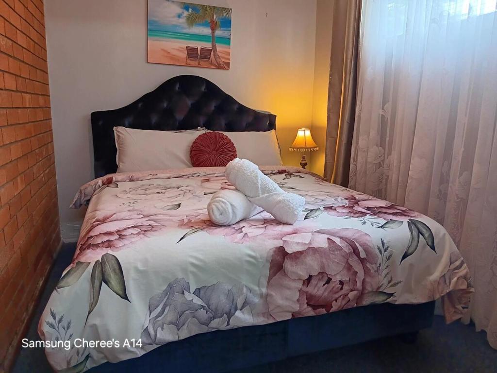 a bed with a stuffed animal laying on it at The Flat 28B on Ordnance in Lithgow