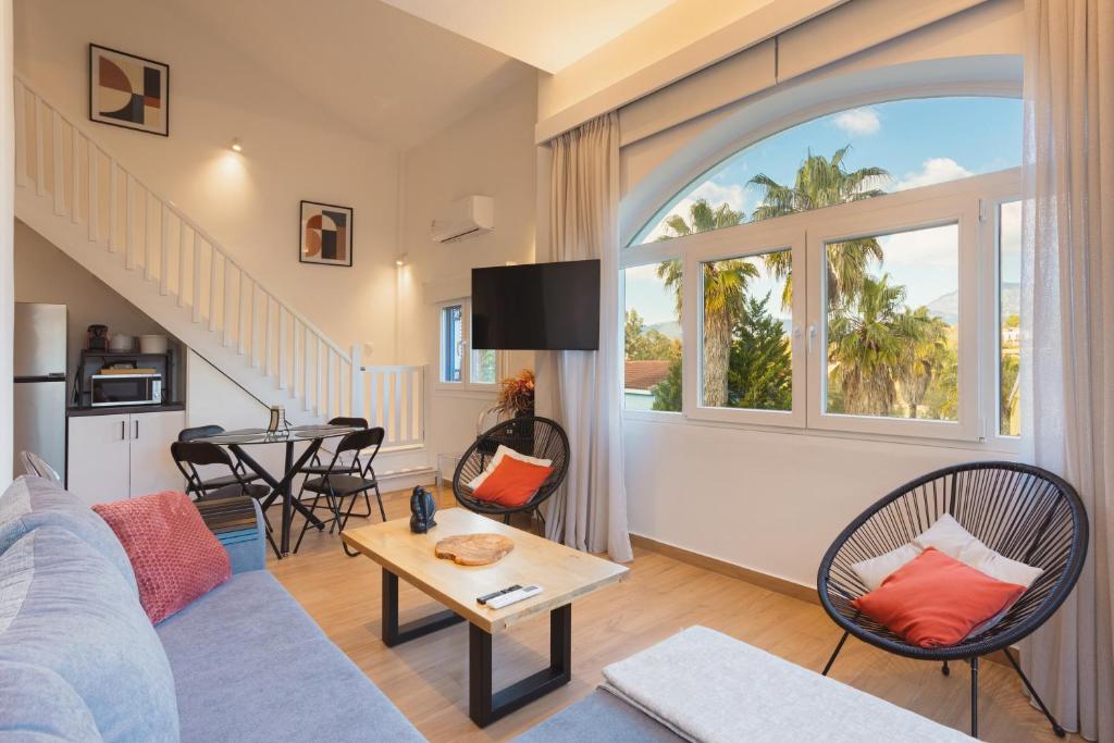 a living room with a couch and a table at Dreamy Seaside Loft Pool, Parking, Fast Wifi in Gouvia