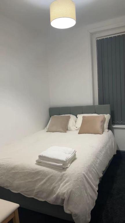 a white bed with towels on top of it at PLUS Properties Westport 2 in Stoke on Trent
