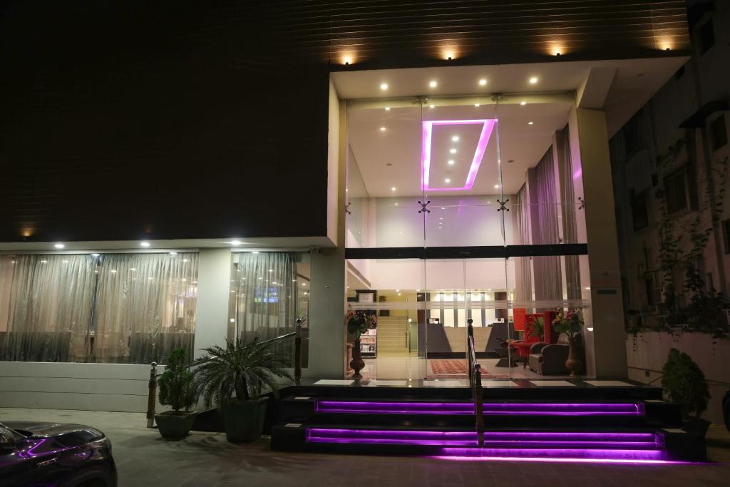 a lobby with purple lights in a building at Veronica Hotel in Vadodara