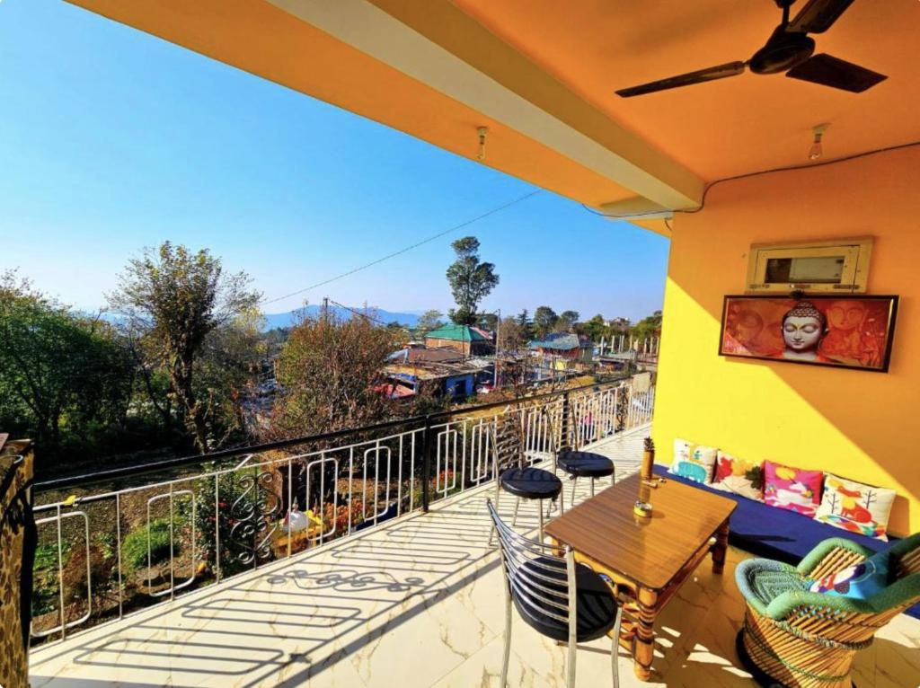 a patio with a table and chairs on a balcony at Kolaveri Homes in Bīr
