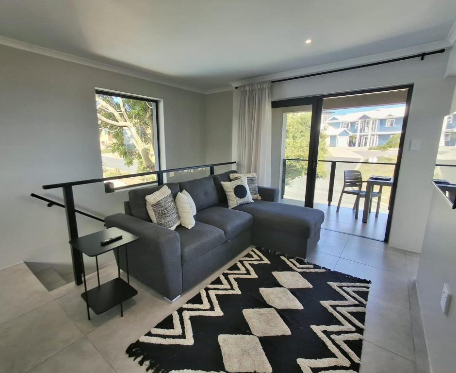 a living room with a couch and a rug at 9 at Sea in Great Brak River