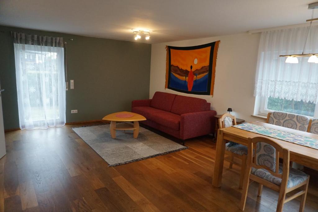 a living room with a red couch and a table at Auszeit in Limbach