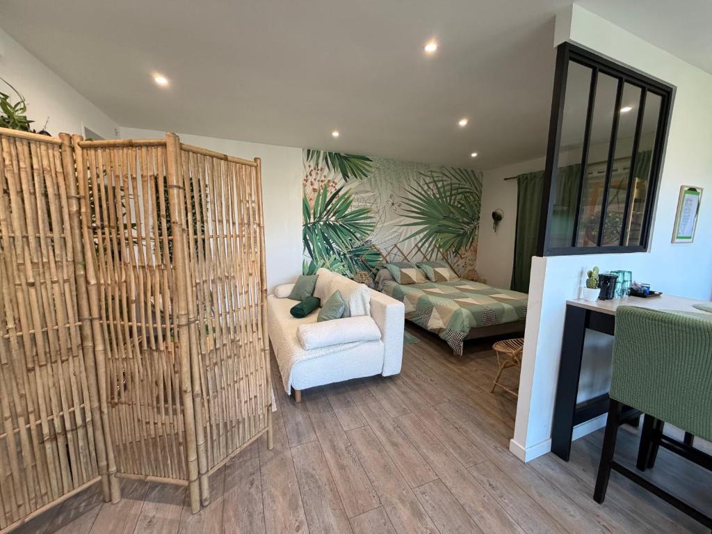 a living room with a couch and a bed at Studio ambiance ZEN in Riantec