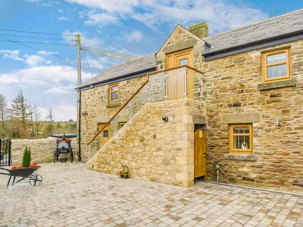 a stone house with a patio in front of it at Swallow Cottage-Ukc6983 in Castleside