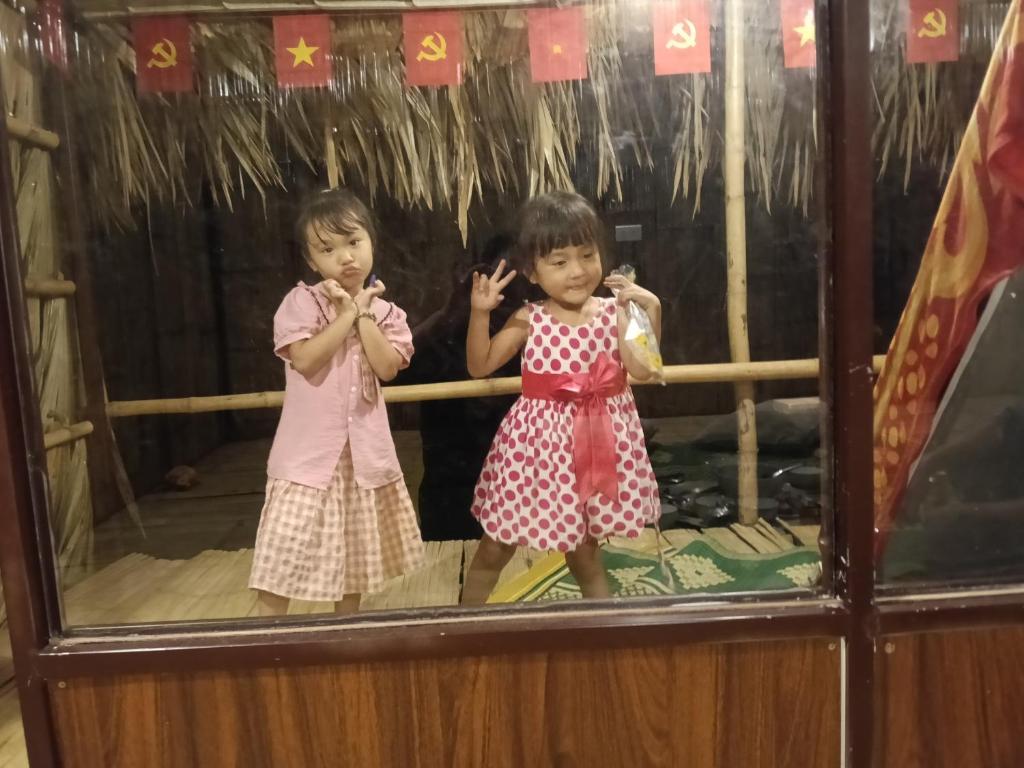 two little girls are standing in a window at Puluongholiday homestay2 in Làng Chiêu
