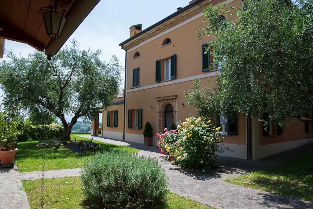 a large building with flowers in front of it at Villa Fiore in Novilara
