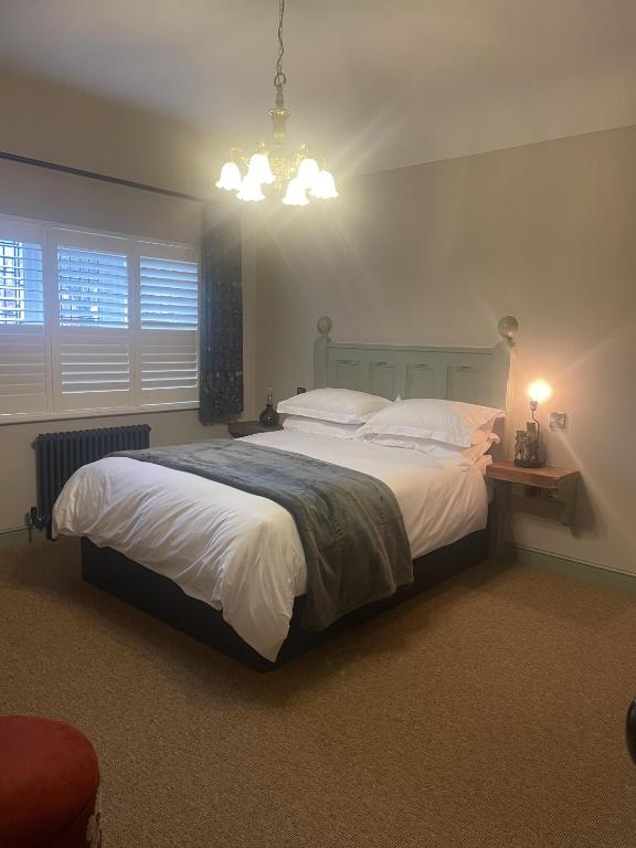 a bedroom with a large bed and a chandelier at The Bear Tattenhall in Tattenhall