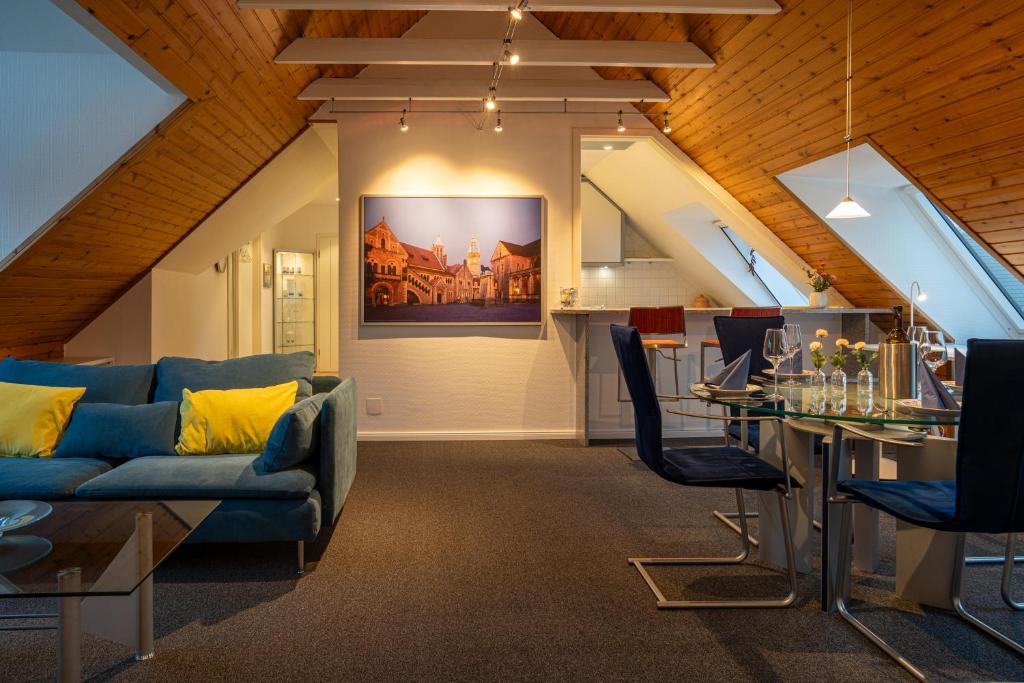a living room with a blue couch and a table at FeWo-Tannenriede in Braunschweig