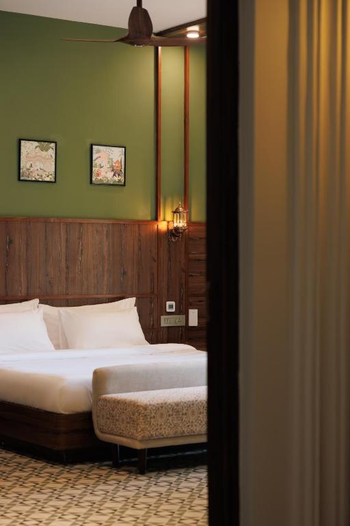 a bedroom with two beds and a green wall at Manthan Beach Resort, Kapu in Pāngāla