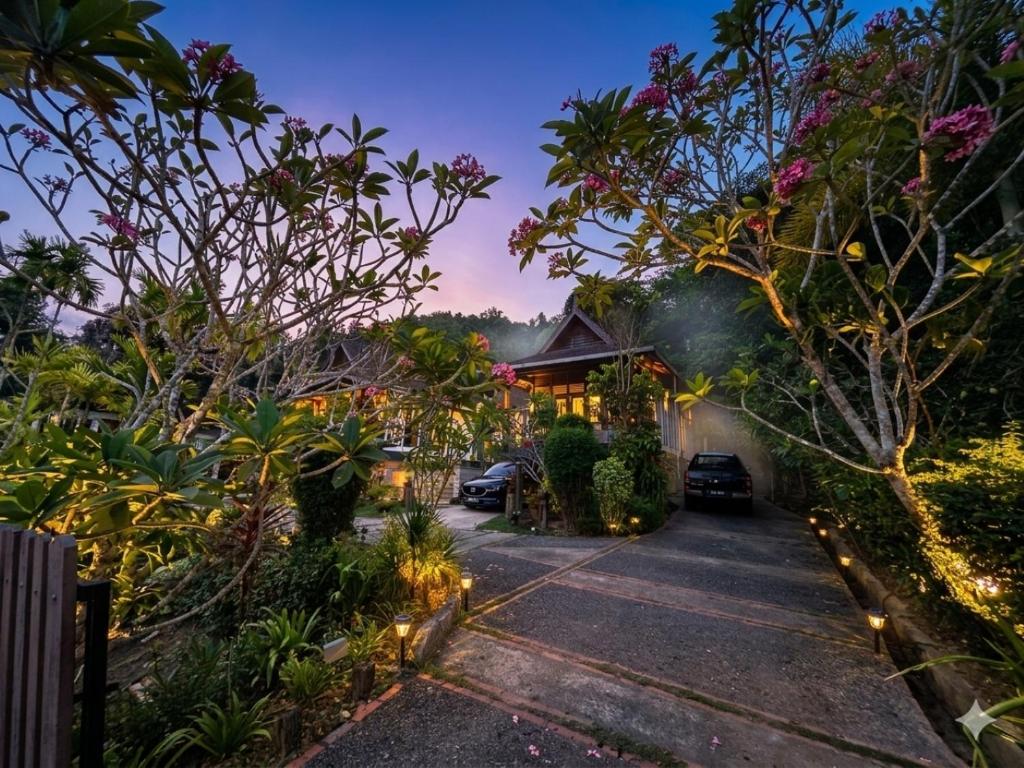 a house with a driveway with trees and lights at The Sanctuary Langkawi in Pantai Cenang