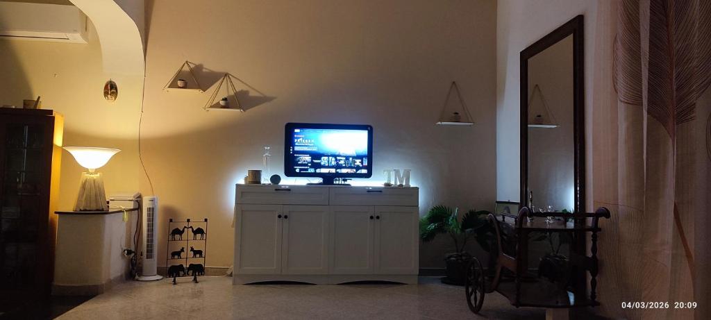 a television on top of a white cabinet in a room at ToMa House in Pellaro