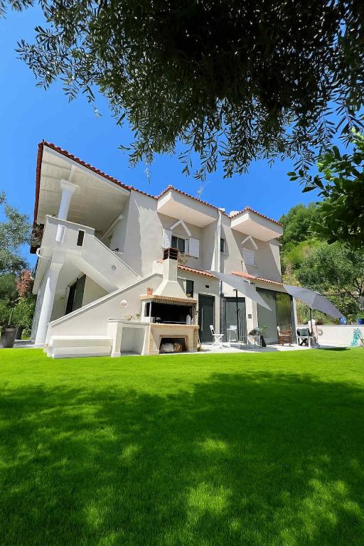 a large building with a lawn in front of it at Blue Breeze in Paralia Vrachou