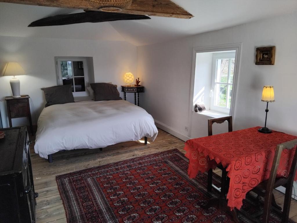 a bedroom with a white bed and a red rug at La chambre du lac in Meaux-la-Montagne