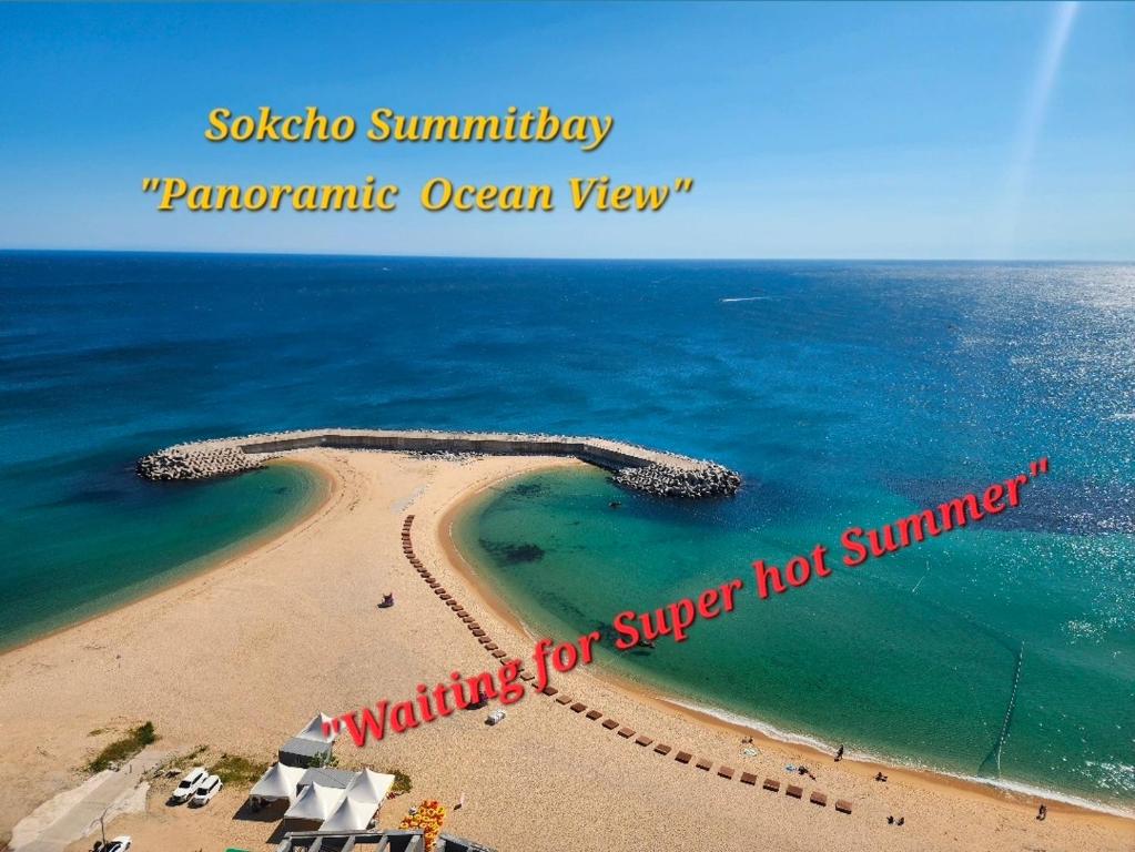 a view of a beach with a sign that reads surfing for super hot summer at Sokcho Summitbay 1705 "Panoramic Ocean View" in Sokcho