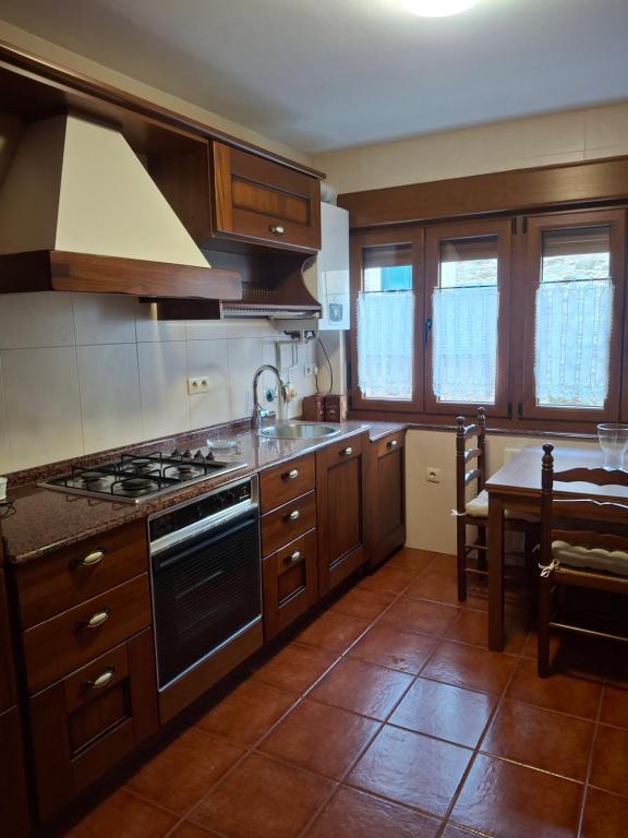 a kitchen with wooden cabinets and a stove top oven at As Pitas 1 in Tapia de Casariego