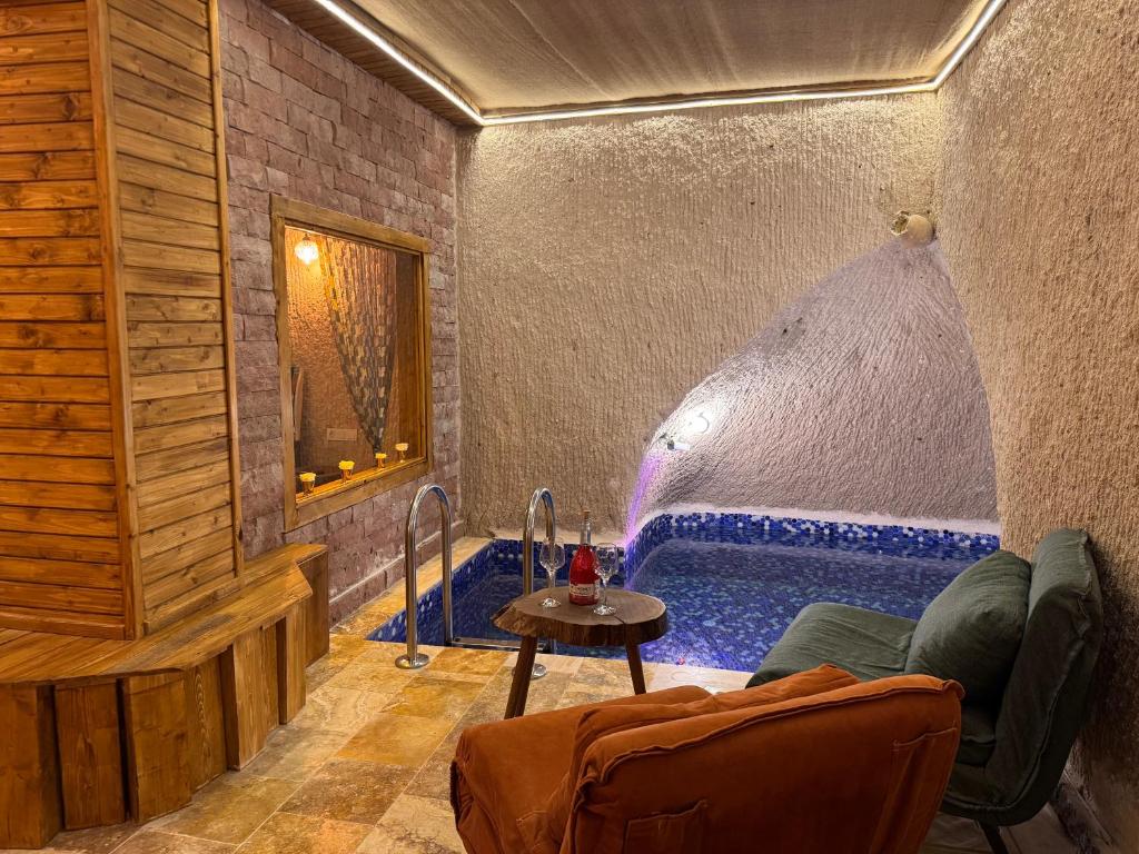 a room with a tub with a couch and a table at Ceran Stone House in Göreme